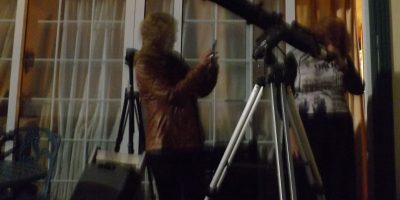 10 cm telescope on a tripod with two people